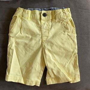 Yellow shorts with button closure.
